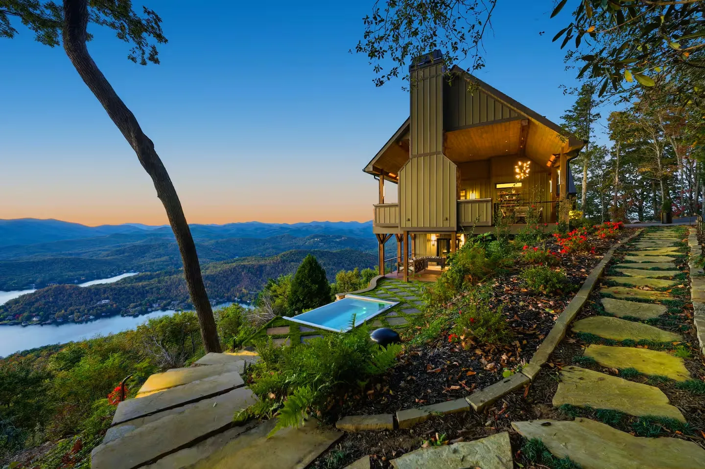 Mountain cabin with a plunge pool above a lake at sunset
