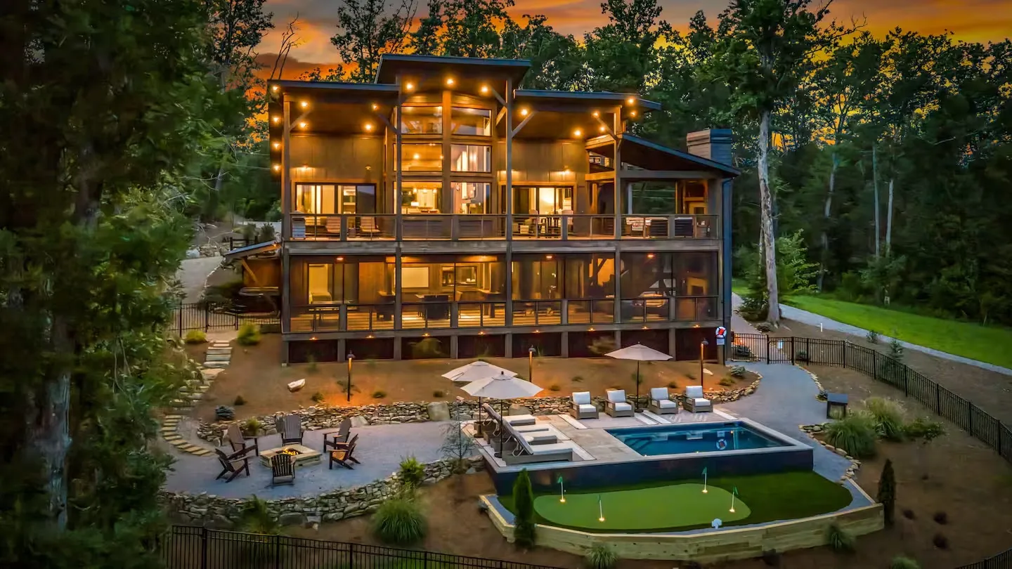 Mountain lodge with a pool, putting green and fire pit at sunset